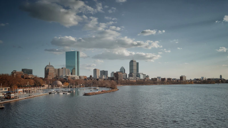 city skyline across body of water under blue and white sunny cloudy sky during daytime