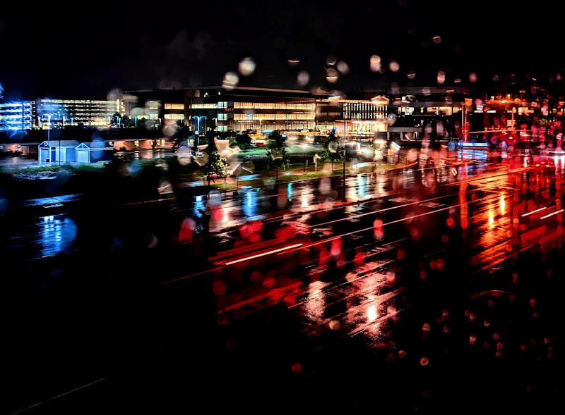 a view of a city at night through a rain covered window
