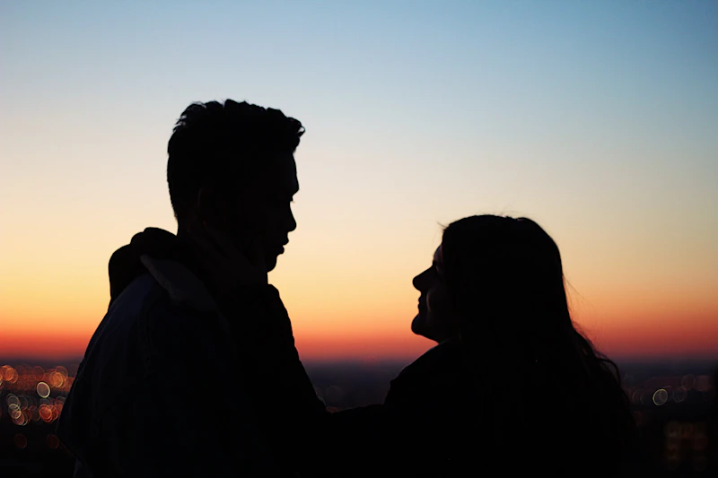 silhouette of man standing beside woman facing each other